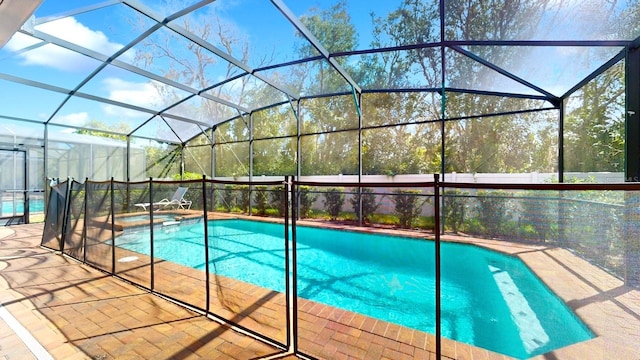 view of swimming pool with glass enclosure and a patio