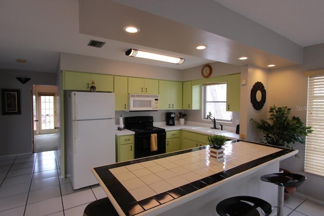 kitchen featuring a kitchen breakfast bar, green cabinetry, white appliances, tile counters, and sink