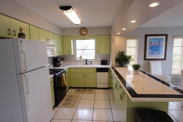 kitchen featuring white appliances, sink, light tile floors, tile countertops, and green cabinets