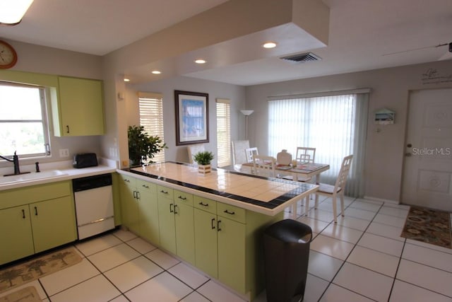 kitchen featuring light tile floors, kitchen peninsula, dishwasher, and sink