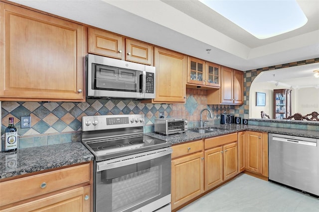 kitchen featuring sink, light tile floors, dark stone countertops, backsplash, and stainless steel appliances