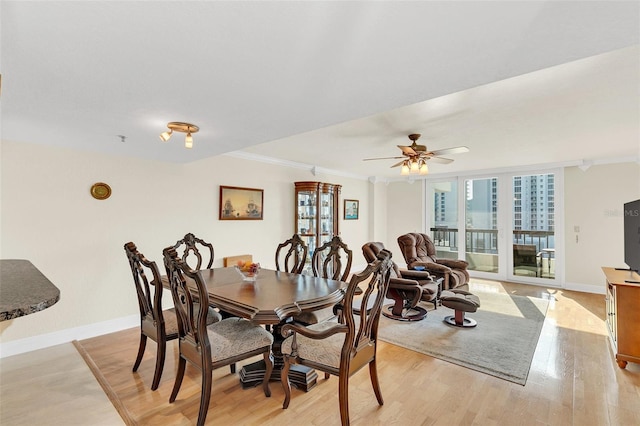 dining space featuring light hardwood / wood-style floors, ceiling fan, and crown molding