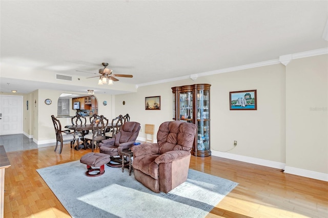 living room featuring ceiling fan, light wood-type flooring, and crown molding