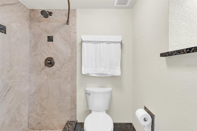 bathroom with toilet and tiled shower