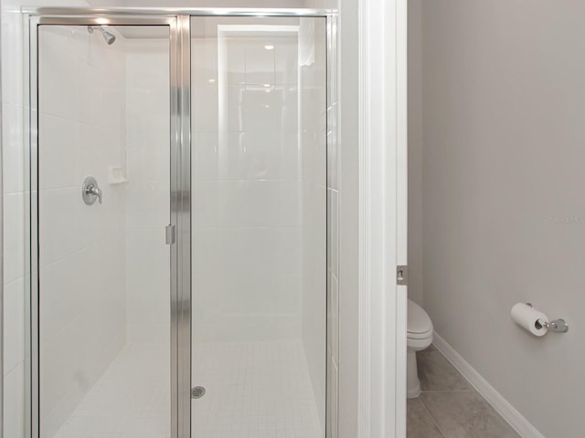 bathroom with a shower with shower door and toilet