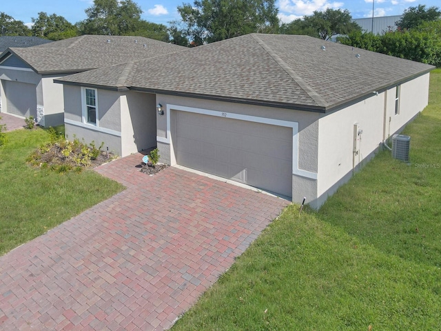 view of front of home featuring a garage, central air condition unit, and a front lawn