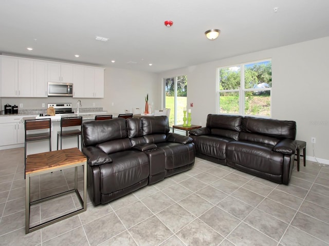 tiled living room featuring sink and a healthy amount of sunlight