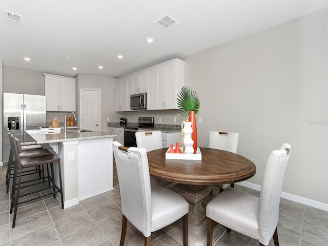 dining room with sink and light tile floors