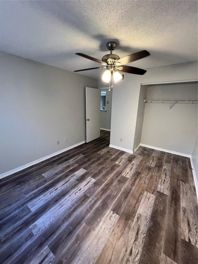 unfurnished bedroom featuring a textured ceiling, a closet, ceiling fan, and dark wood-type flooring