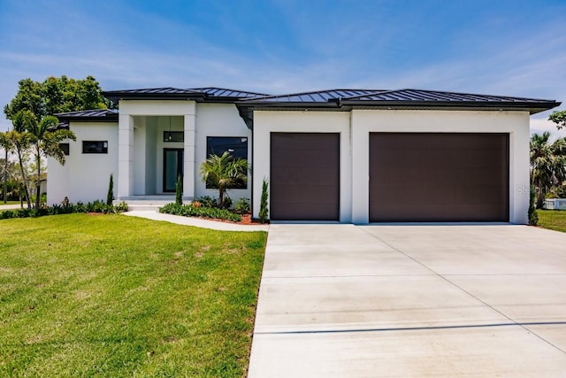 prairie-style home featuring a garage and a front lawn