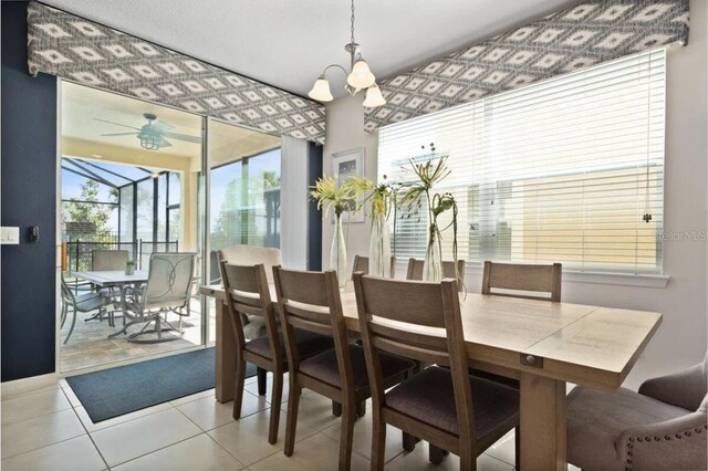 dining room with tile patterned floors and ceiling fan with notable chandelier