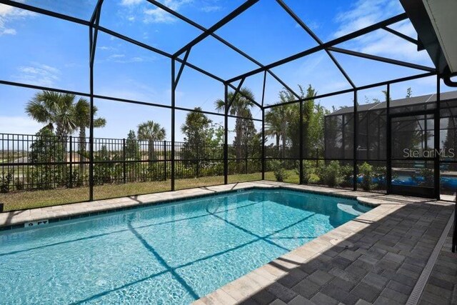 view of pool featuring a patio and glass enclosure