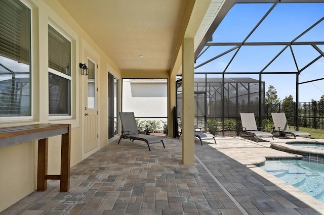 view of patio featuring a swimming pool with hot tub and glass enclosure