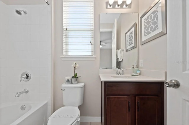 full bathroom featuring a healthy amount of sunlight, vanity, tiled shower / bath, and toilet