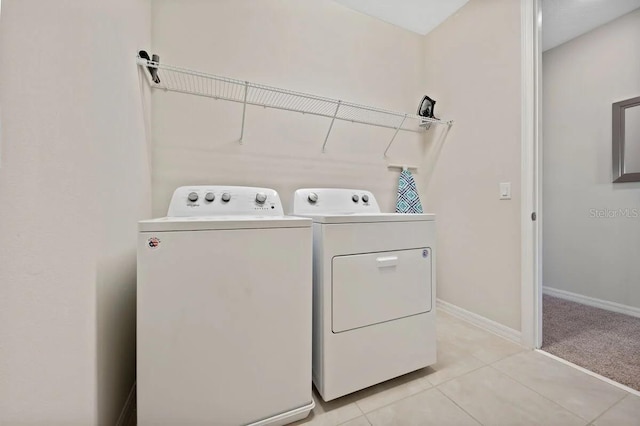 clothes washing area featuring washing machine and dryer and light tile patterned floors