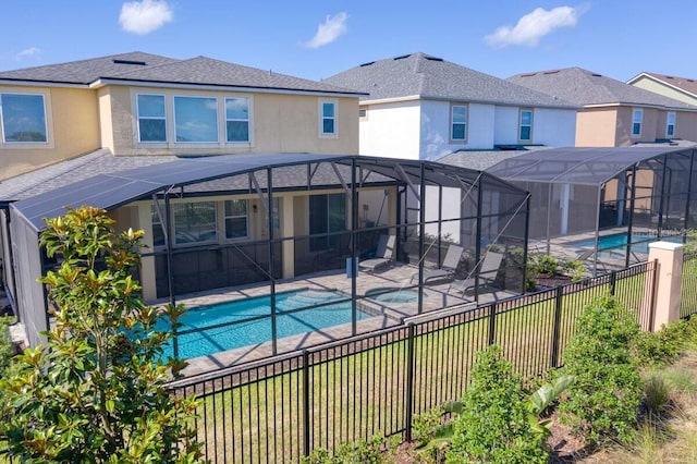 view of swimming pool featuring glass enclosure