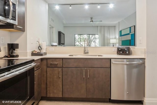 kitchen with ceiling fan, sink, rail lighting, appliances with stainless steel finishes, and dark brown cabinetry