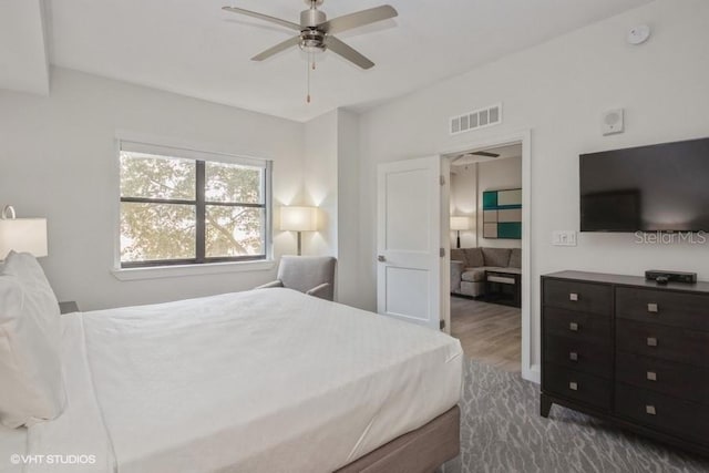 bedroom with dark hardwood / wood-style flooring and ceiling fan