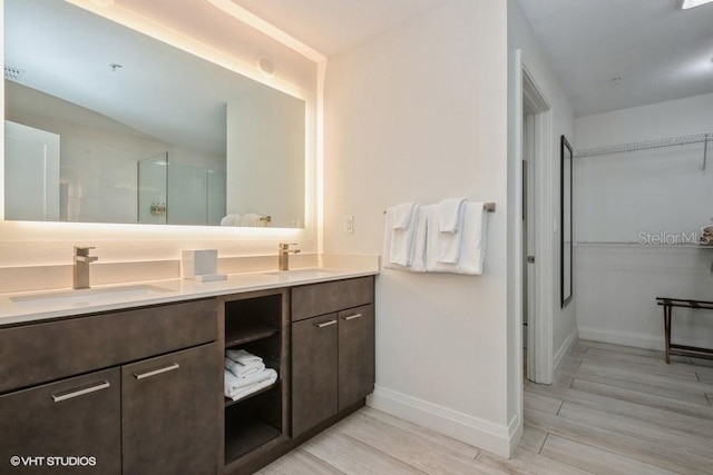 bathroom with hardwood / wood-style flooring, dual sinks, and oversized vanity