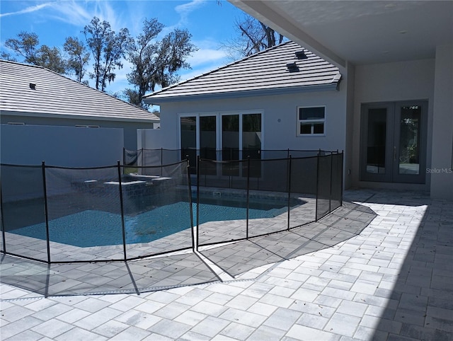 view of swimming pool featuring fence, french doors, a fenced in pool, and a patio