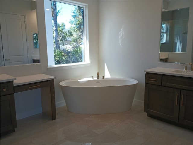 bathroom featuring a soaking tub, vanity, and baseboards