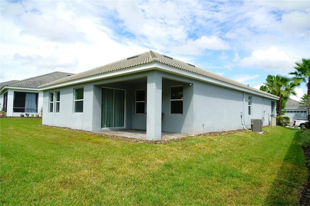 rear view of house with a lawn, a patio area, and central AC