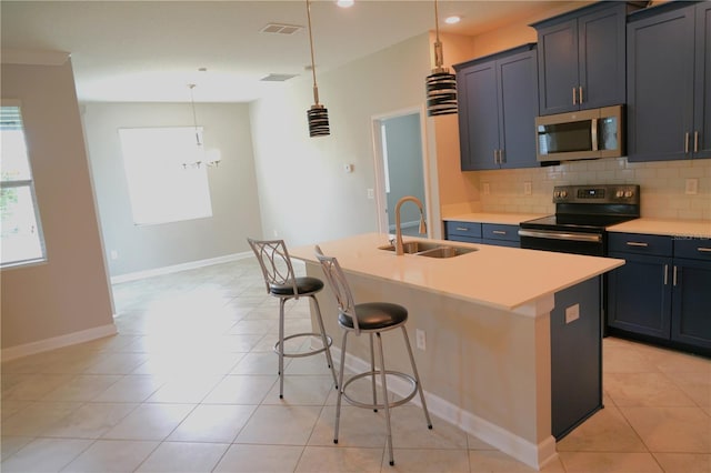 kitchen featuring a breakfast bar, tasteful backsplash, a center island with sink, appliances with stainless steel finishes, and sink