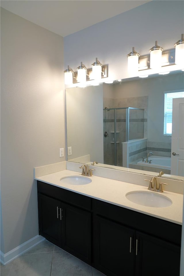 bathroom with independent shower and bath, tile floors, dual sinks, and vanity with extensive cabinet space