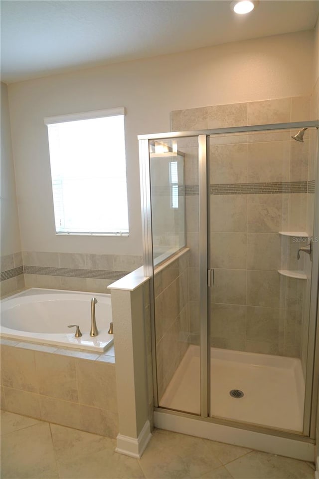 bathroom with shower with separate bathtub and tile flooring