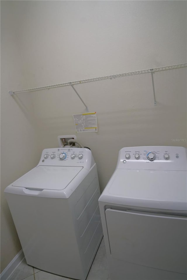 washroom featuring washer hookup, washer and dryer, and light tile floors