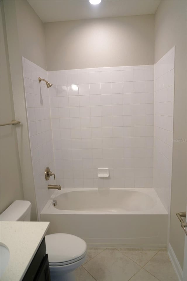 full bathroom with tiled shower / bath combo, toilet, tile floors, and vanity