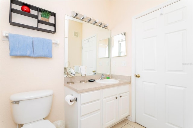 bathroom with toilet, large vanity, and tile flooring