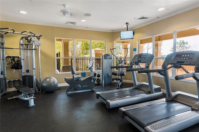 exercise room with a textured ceiling, ceiling fan, and ornamental molding