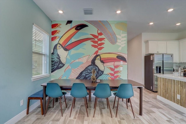 dining room with plenty of natural light and light hardwood / wood-style flooring