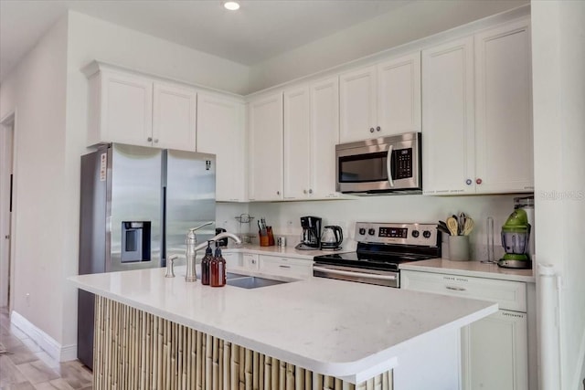 kitchen featuring white cabinets, appliances with stainless steel finishes, sink, and light wood-type flooring