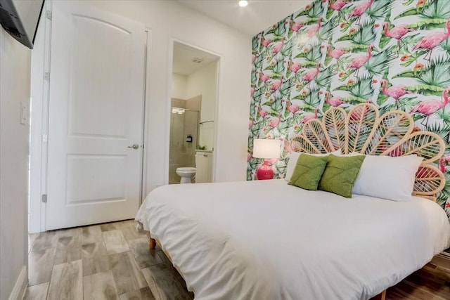 bedroom with light hardwood / wood-style floors and ensuite bathroom