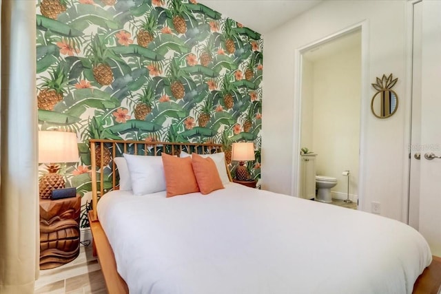 bedroom with ensuite bath and light hardwood / wood-style flooring