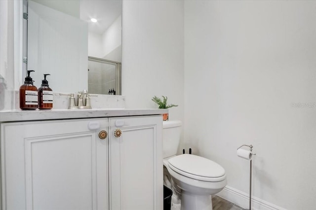 bathroom featuring toilet, vanity, and hardwood / wood-style floors