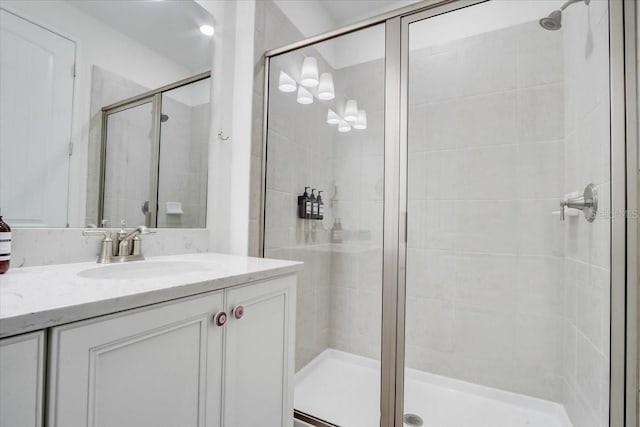 bathroom featuring large vanity and a shower with shower door