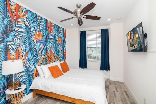 bedroom with light hardwood / wood-style floors and ceiling fan