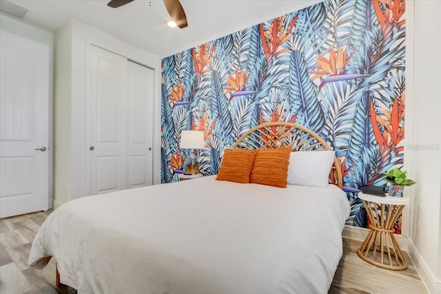 bedroom with a closet, ceiling fan, and light hardwood / wood-style flooring