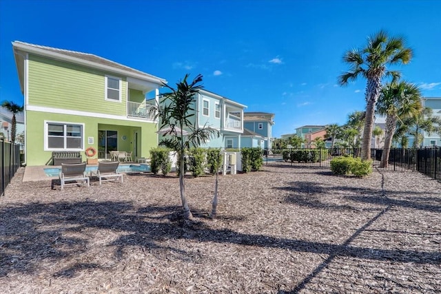 back of property with a balcony and a patio