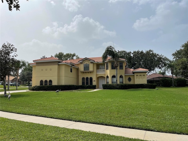 mediterranean / spanish-style home featuring a front yard