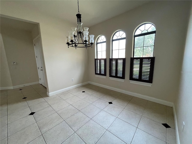 empty room featuring an inviting chandelier and light tile floors