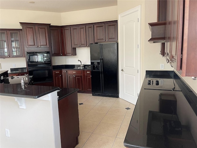 kitchen featuring light tile flooring, dark brown cabinets, and black appliances