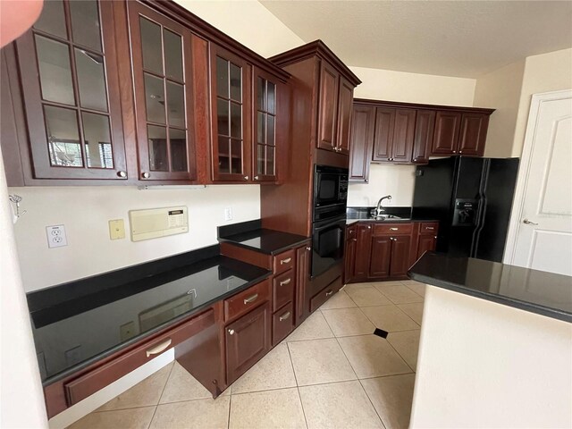 kitchen featuring sink, dark brown cabinetry, black appliances, and light tile floors