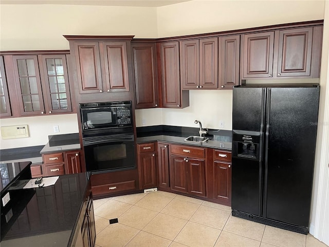 kitchen with light tile floors, black appliances, and sink