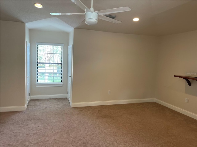 carpeted empty room with ceiling fan and lofted ceiling