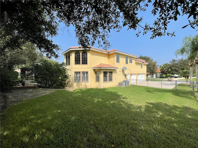 back of house with central AC unit and a lawn