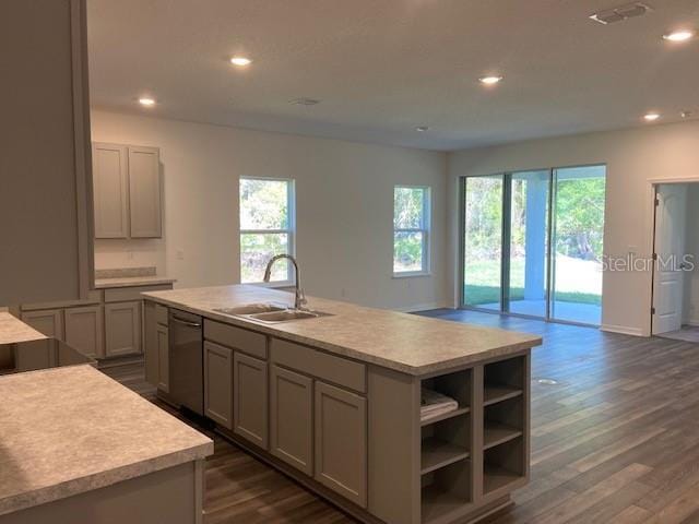 kitchen with gray cabinets, dishwasher, sink, a kitchen island with sink, and dark wood-type flooring